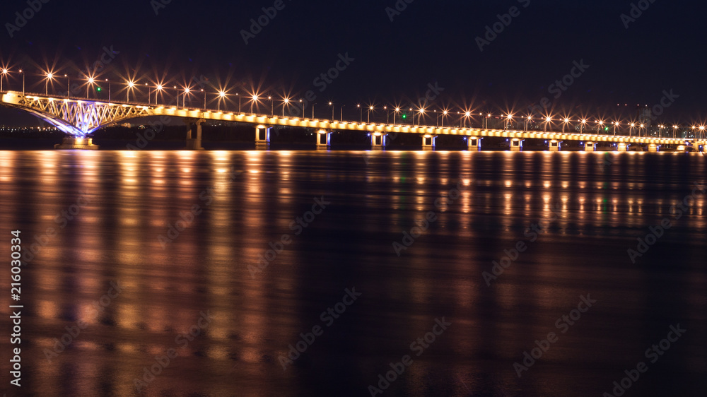 Song exposure shot of the brigde above Volga river with beautyfull lights reflected at water