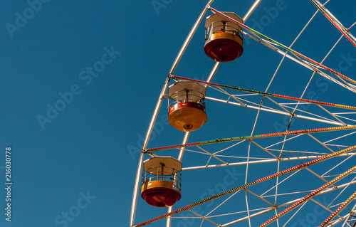 Colourful Ferris wheel shot against a deep blue sky