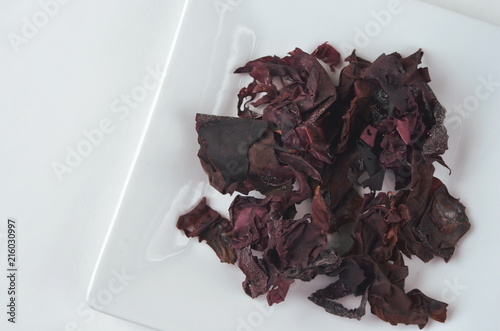 Top view dulse (Palmaria palmata) seaweed on a white plate with copy space.