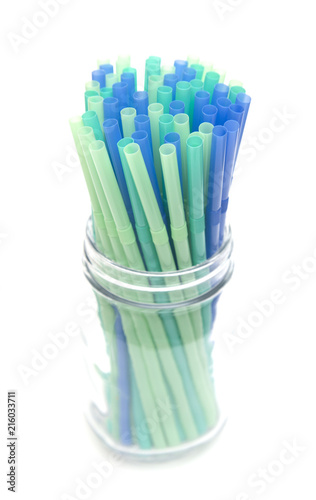 Bunch of Straws in a Glass Container on a White Background