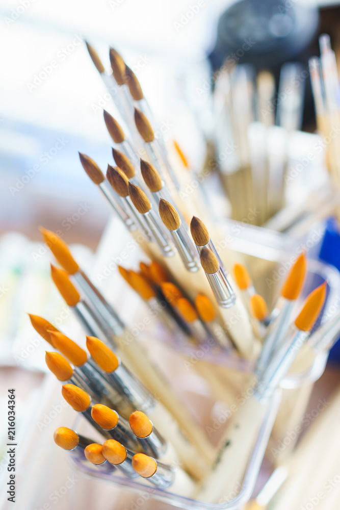 several different brushes made from natural wool for watercolors and oil in a box, top view and beautiful bokeh. several different brushes made from natural wool for watercolors and oil in a box, top view and beautiful bokeh.