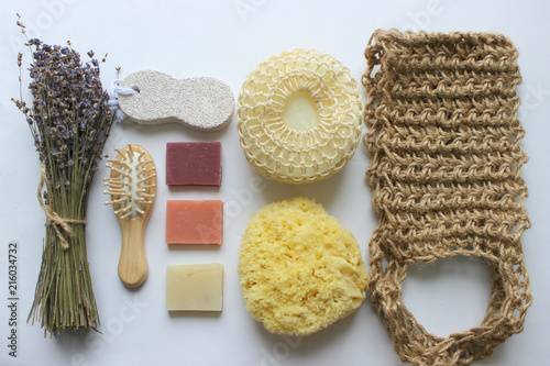 Spa accessories-sponge, natural soap, essential oil, pumice, salt, washcloth, comb, candles on a light background, top view. The concept of a healthy lifestyle. Beauty, skin care. flat position photo