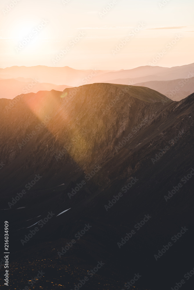 Obraz premium A purple and pink landscape view of the Rocky Mountains during sunrise.