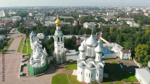 Flight of the camera over Saint Sophia orthodox cathedral and church of Resurrection of Jesus in a sunny summer day in Vologda Kremlin. photo