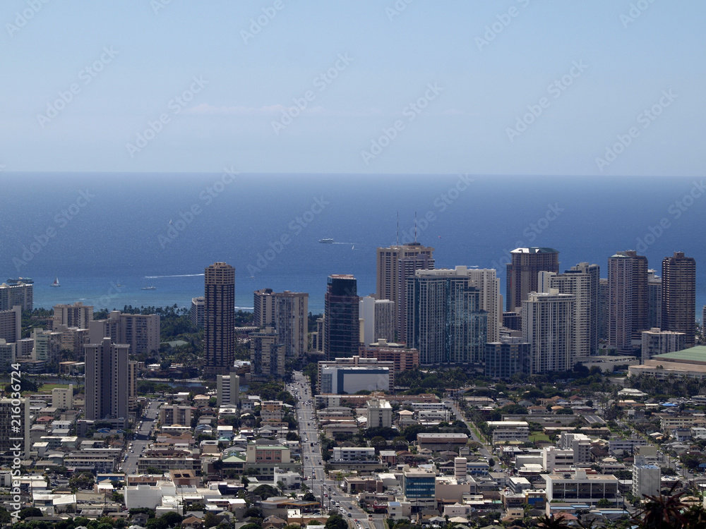 Fototapeta premium Aerial of Honolulu, Waikiki, Buildings, parks, hotels and Condos with Pacific Ocean and boats stretching into the distance