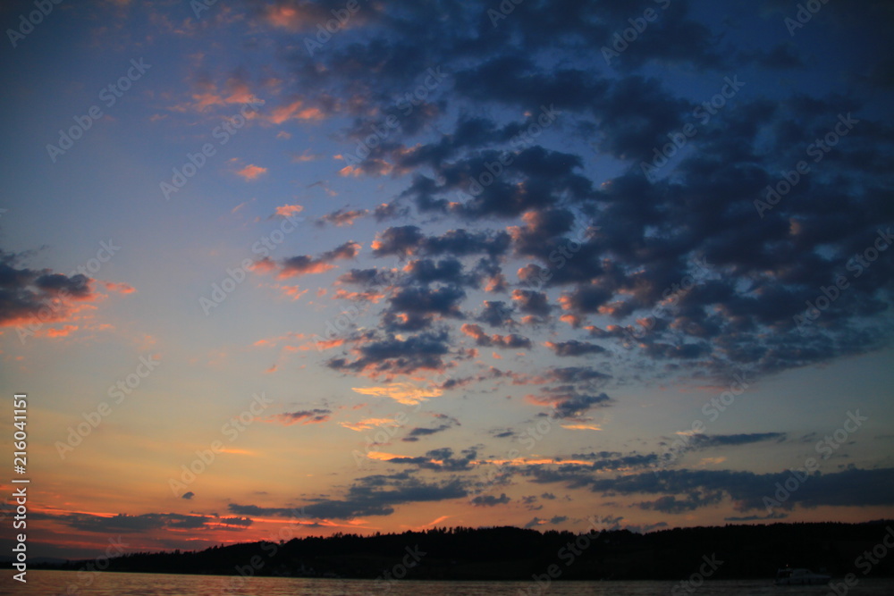 Schäfchen-Wolken am Abendhimmel über See