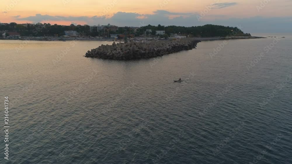 Beautiful Sunset with Horbor ,Lighthouse and man with rowing kayak Beautiful Sunset with Horbor ,Lighthouse and man with rowing kayak