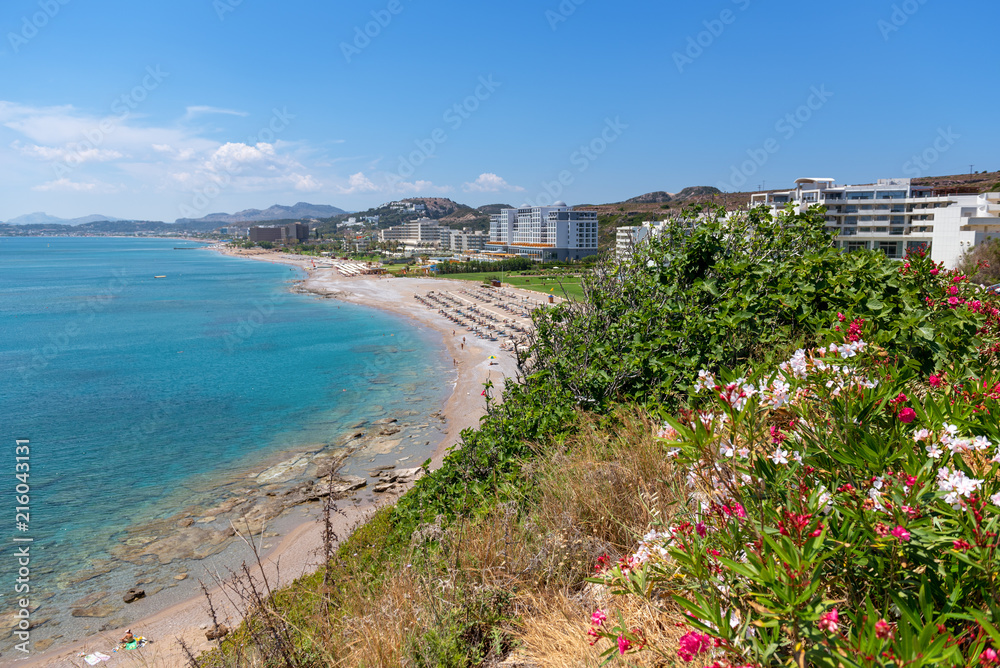 View of sea coast with sandy beach and crustal sea water in Faliraki. Rhodes island, Dodecanese, Greece.