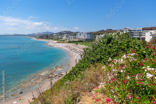 Fototapeta Naklejka Na Ścianę i Meble -  View of sea coast with sandy beach and crustal sea water in Faliraki. Rhodes island, Dodecanese, Greece.