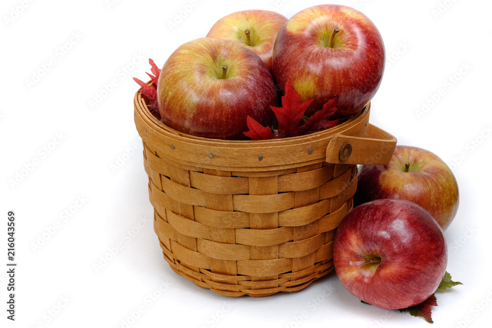 woven wooden basket with fresh mcintosh apples isolated on a white background