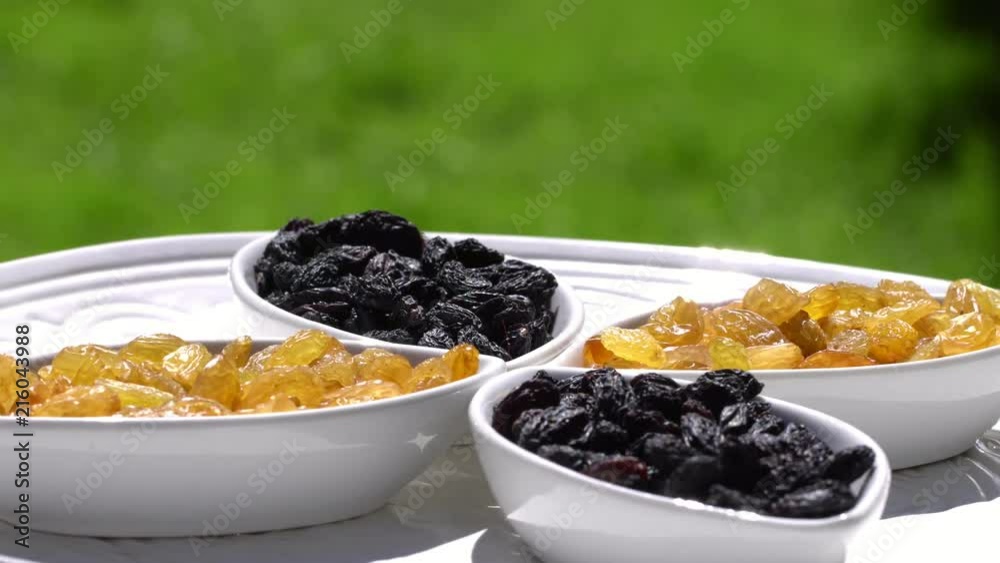 Dark and light raisin largely. Healthy food. Dried fruits. Movement in a circle. 4K.