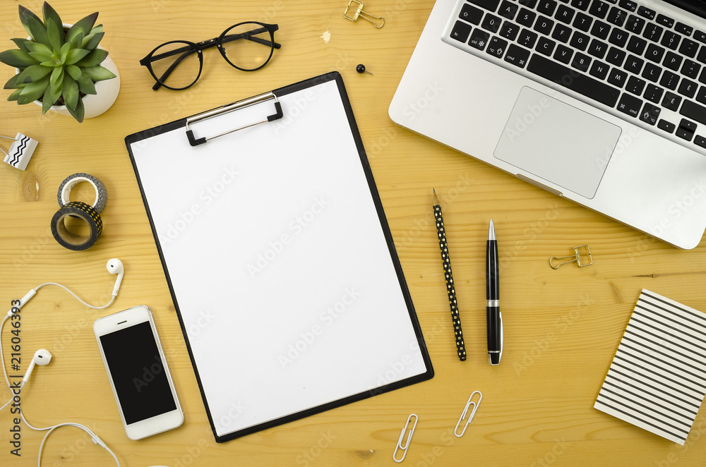 Home office desk workspace with with silver notebook, smartphone and office accessories on wood desk background. Home office desk workspace with with silver notebook, smartphone and office accessories on wood desk background.