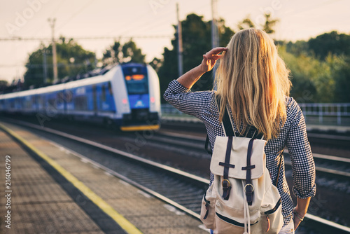 Photo woman is looking at arriving train at a railway station
