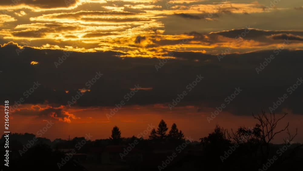 Sunset behind clouds over land Sunset behind clouds over land