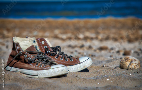 Brown canvas sneakers at beach