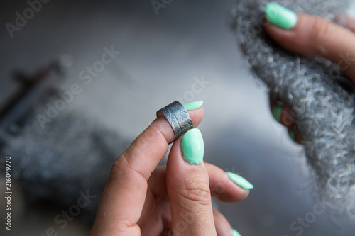 The process of making silver jewellery. Female artist hands close up. Crafting a silver ring, see the entire series. photo