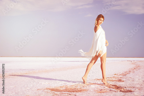 Girl walking on the salt lake, with abstract lines of sand. The concept of tourism, recreation, Spa treatments.
