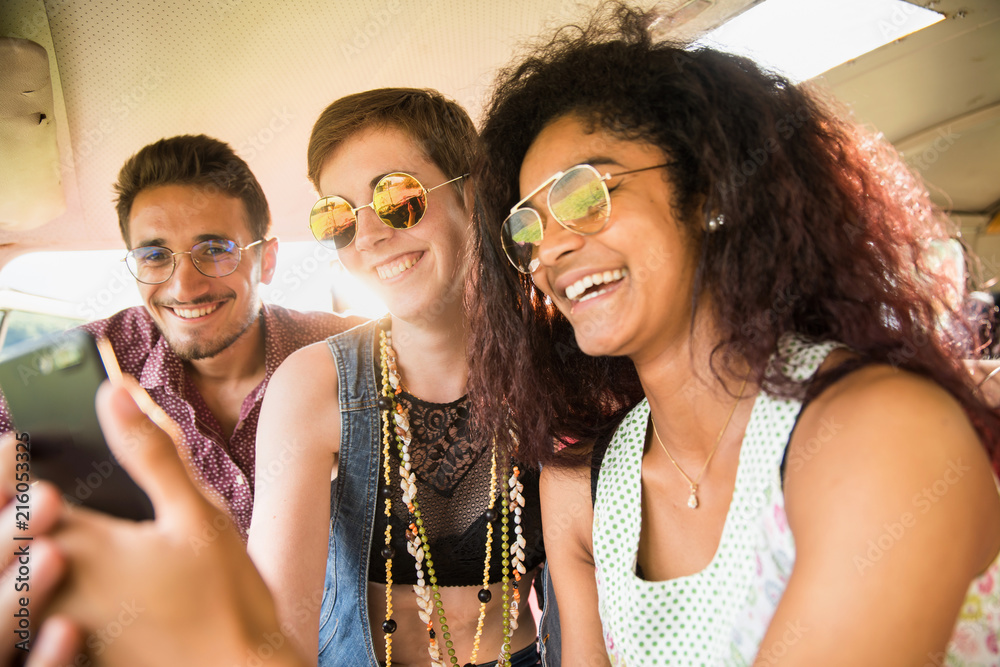 Obraz premium Mixed group of happy young people in a camper van having fun 