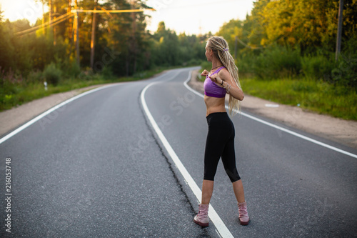 Young woman warms up before jogging on the road. Running.