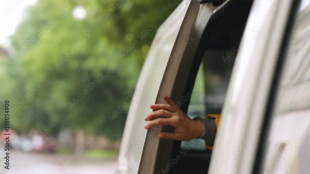 closeup view of female person raising up hand from a car for checking if it still raining outside then opening colorful umbrella and going outdoor from a car transport life comfort casual look closeup view of female person raising up hand from a car for checking if it still raining outside then opening colorful umbrella and going outdoor from a car transport life comfort casual look
