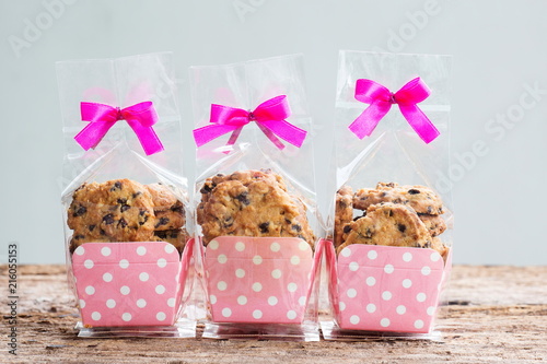 Chocolate chip cookies in plastic bag packaging with ribbon bow.