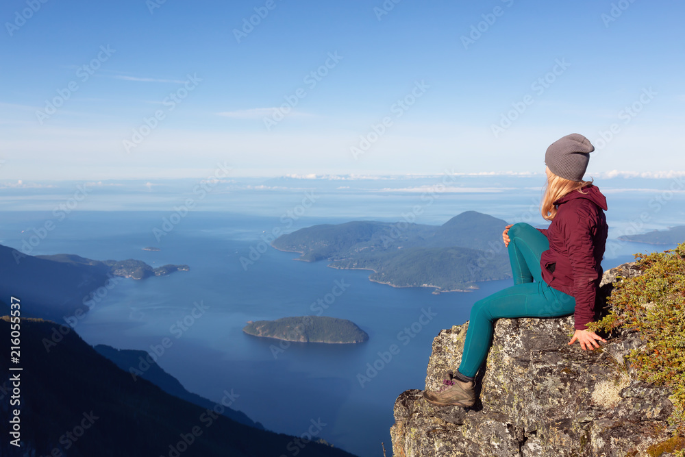 Adventurous woman is enjoying the view in the mountains during a sunny summer day. Taken on Mount Brunswick, Lions Bay, North of Vancouver, BC, Canada.
