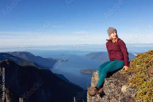 Adventurous woman is enjoying the view in the mountains during a sunny summer day. Taken on Mount Brunswick, Lions Bay, North of Vancouver, BC, Canada.