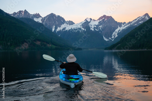 Adventurous man kayaking in the water surrounded by the Beautiful Canadian Mountain Landscape. Taken in Jones Lake, near Hope, East of Vancouver, BC, Canada.