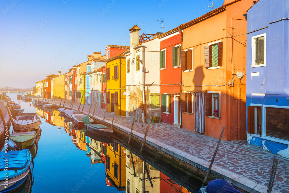 Beautiful view of the canals of Burano with boats and beautiful, colorful buildings. Burano village is famous for its colorful houses. Venice, Italy.