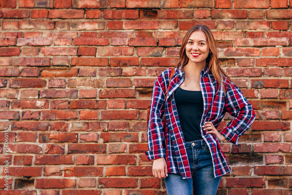 Portrait of young woman standing against brick wall Portrait of young woman standing against brick wall