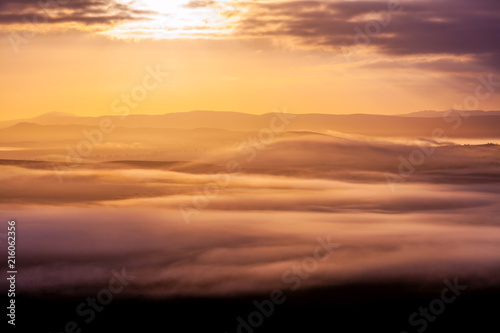Layers of clouds and mountains at beautiful sunset