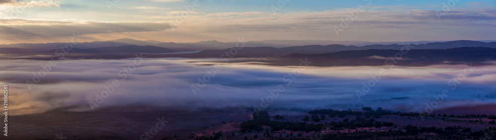 Large panorama of Flinders Ranges mountains covered in low clouds at sunrise in South Australia