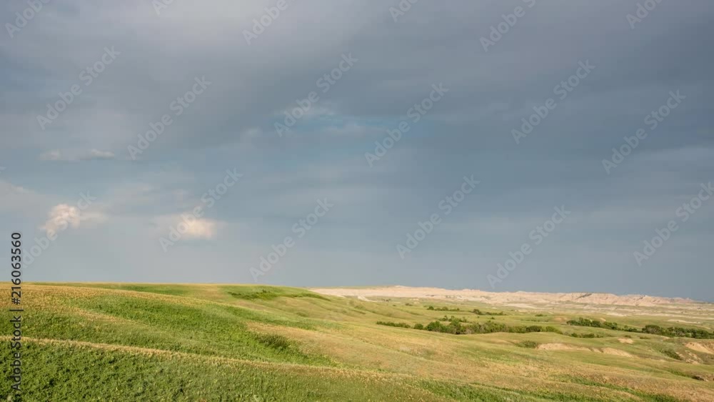 TL Badlands - Sunset Falls Over Grassy Plan with Badlands in Background TL Badlands - Sunset Falls Over Grassy Plan with Badlands in Background