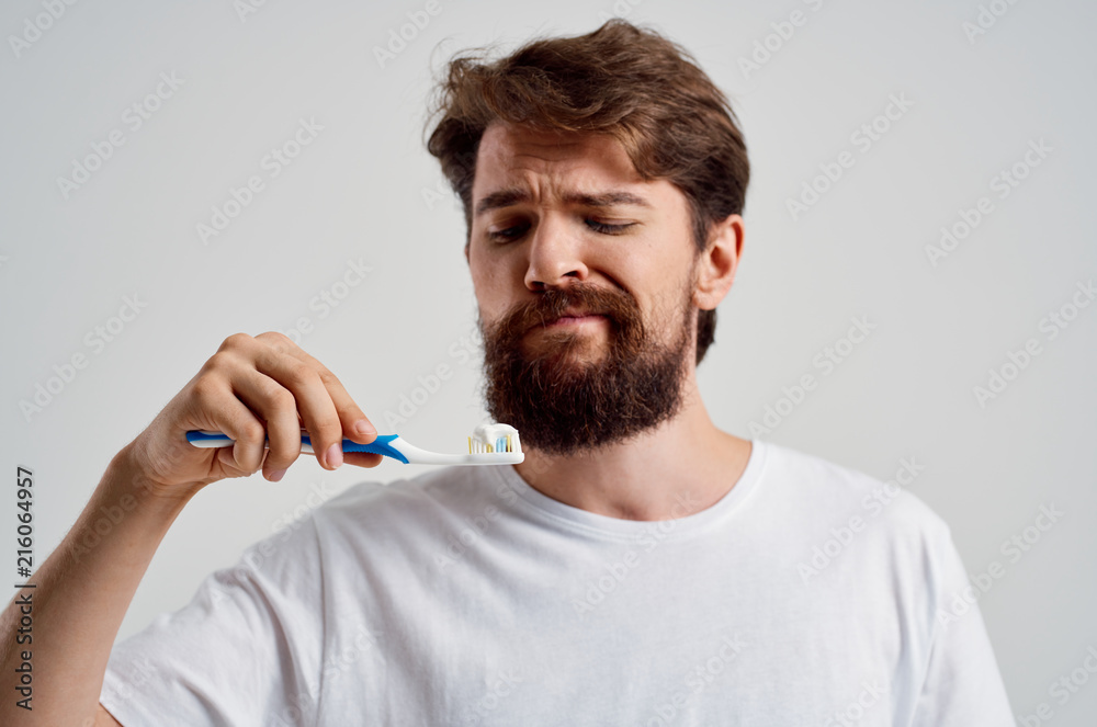 man looking at a toothbrush man looking at a toothbrush
