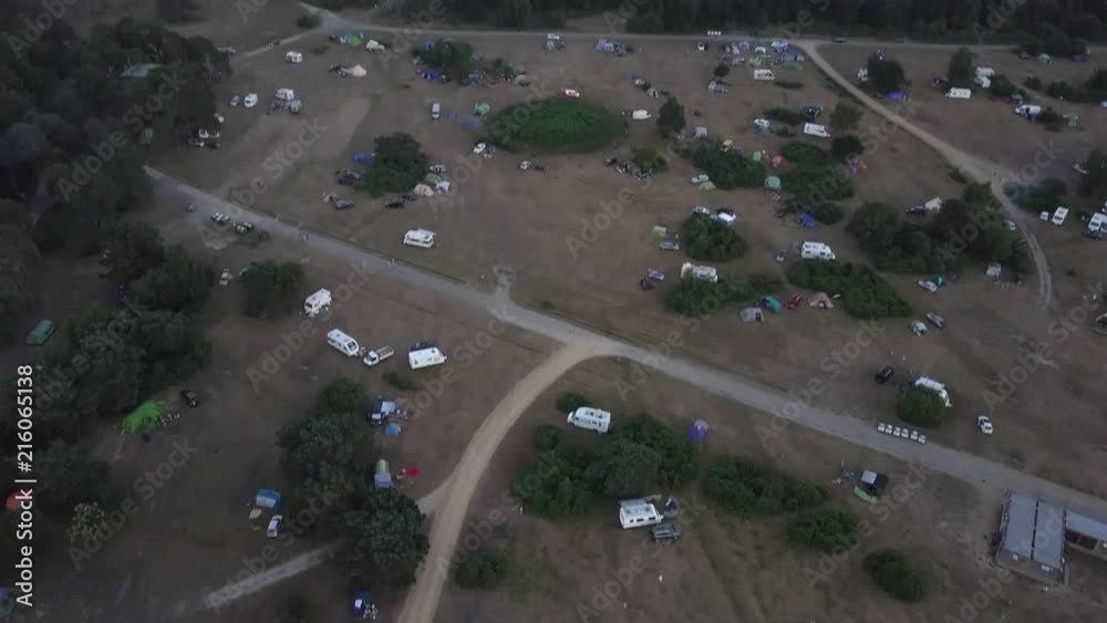 Drone aerial view panning up revealing Round Hill camp site New Forest South England UK during sunset golden hour.