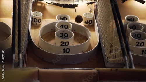 Slo-motion upward shot of a skee-ball bouncing around the baskets of the skee-ball machine. photo