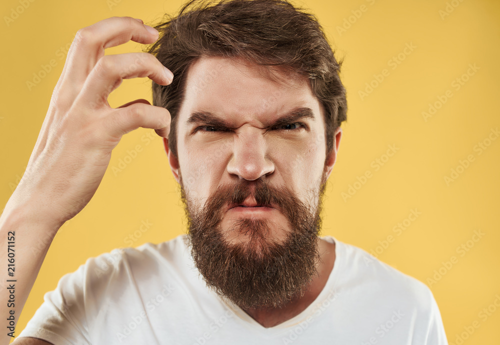 angry man with a beard on a yellow background portrait angry man with a beard on a yellow background portrait