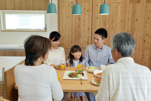 自宅で食事を楽しむ3世代家族