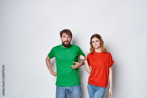 happy young couple in color t-shirts on a light background