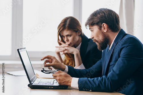 man and woman working on laptop in office
