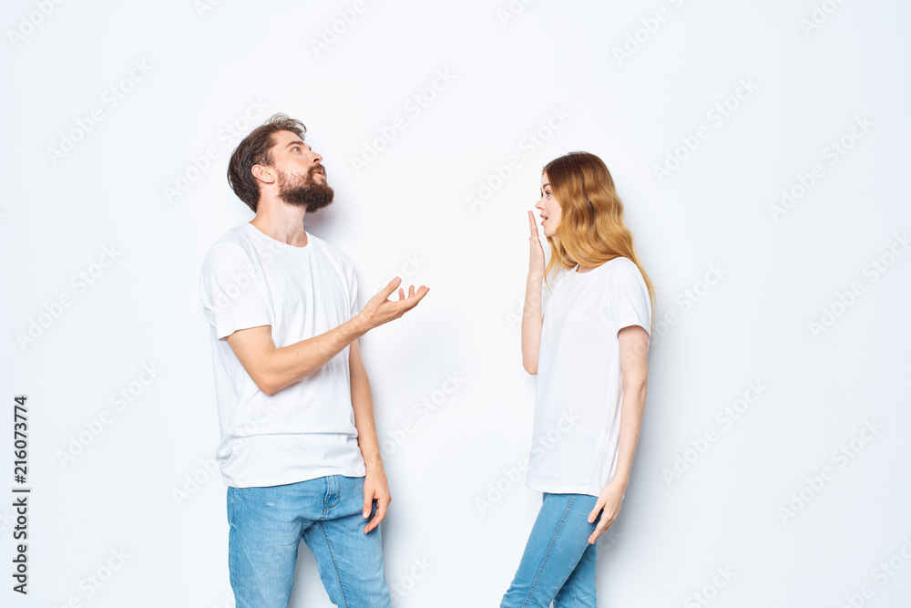 young couple talking in white t-shirts on a light background young couple talking in white t-shirts on a light background