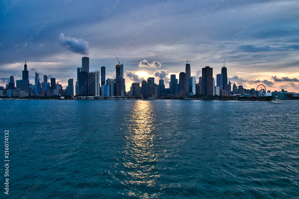 Sunset over the city of Chicago skyline with added interest in cloudscape and reflections during summer.