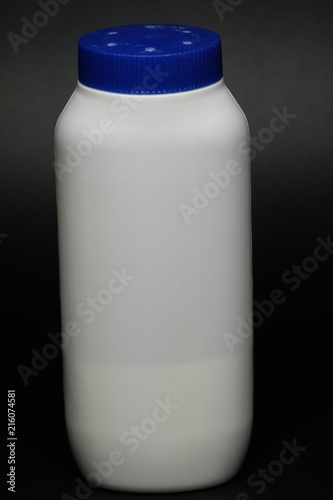 White plastic baby powder bottle isolated on black background