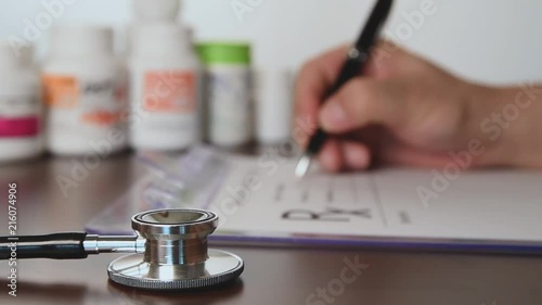 Male doctor hands writing rx prescription.