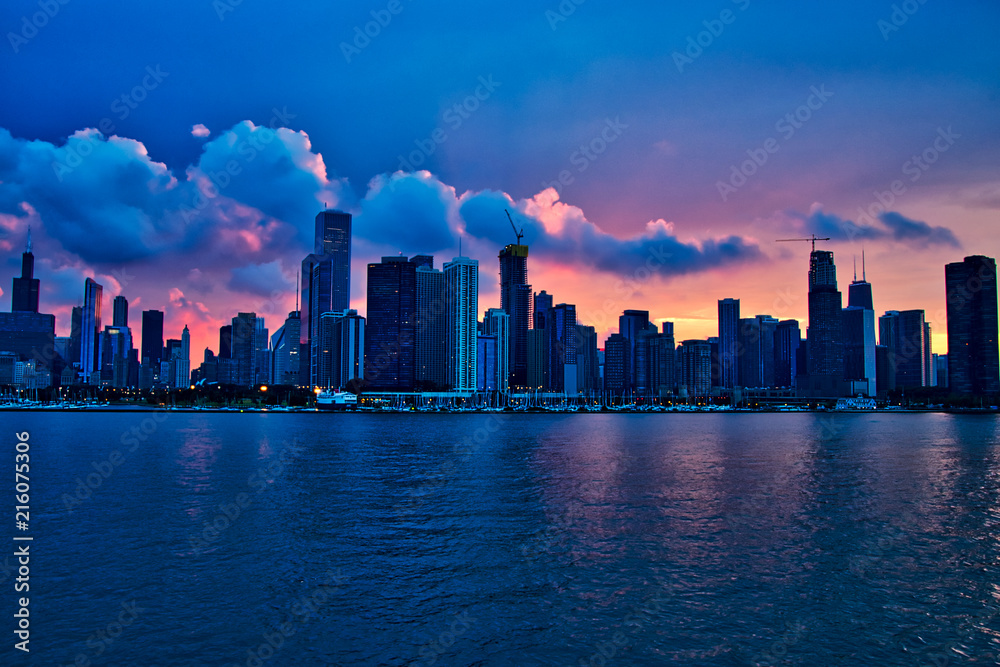 Sunset over city of Chicago create shadows of the skyline, seen from Lake Michigan during summer boat ride.