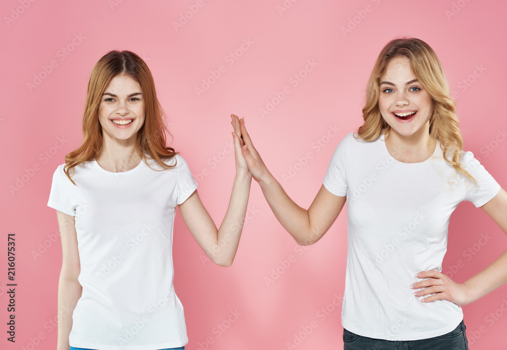 girlfriends in white t-shirts hold their hands together girlfriends in white t-shirts hold their hands together
