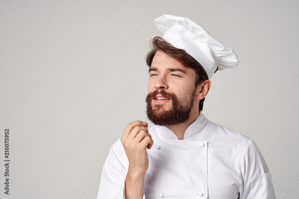 cook in uniform on a light kitchen background cook in uniform on a light kitchen background