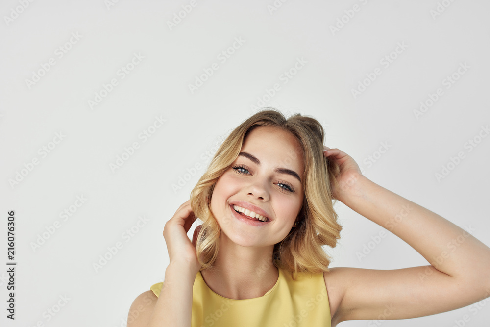 blonde woman smiling on a light background blonde woman smiling on a light background