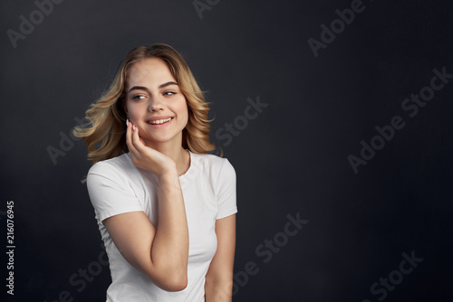 beautiful blonde in a T-shirt on a gray background