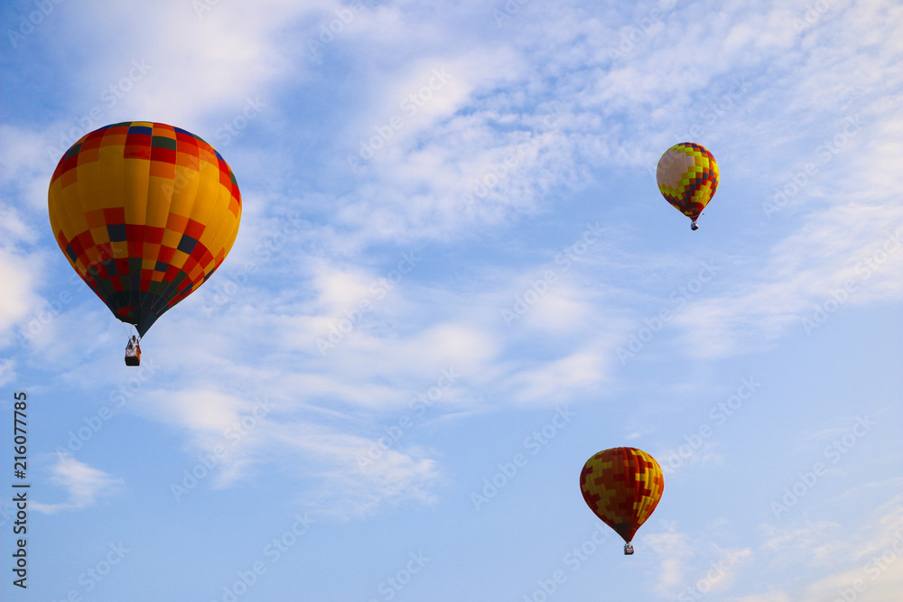 Obraz premium colorful hot air balloon against blue sky. hot air balloon is flying in white clouds. beautiful flying on hot air balloon